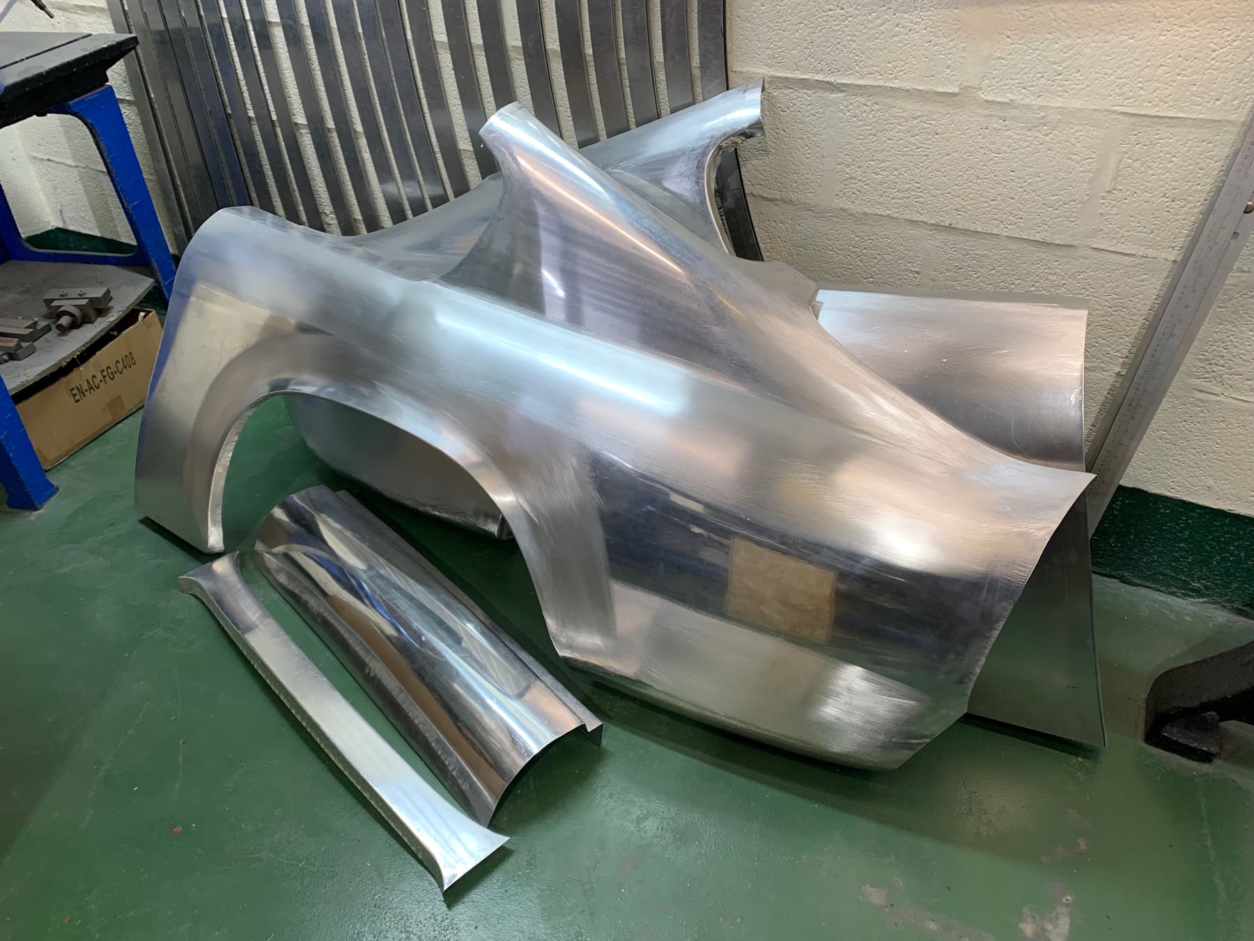 Hand-shaped aluminium body panels for a classic car, freshly wheeled and polished