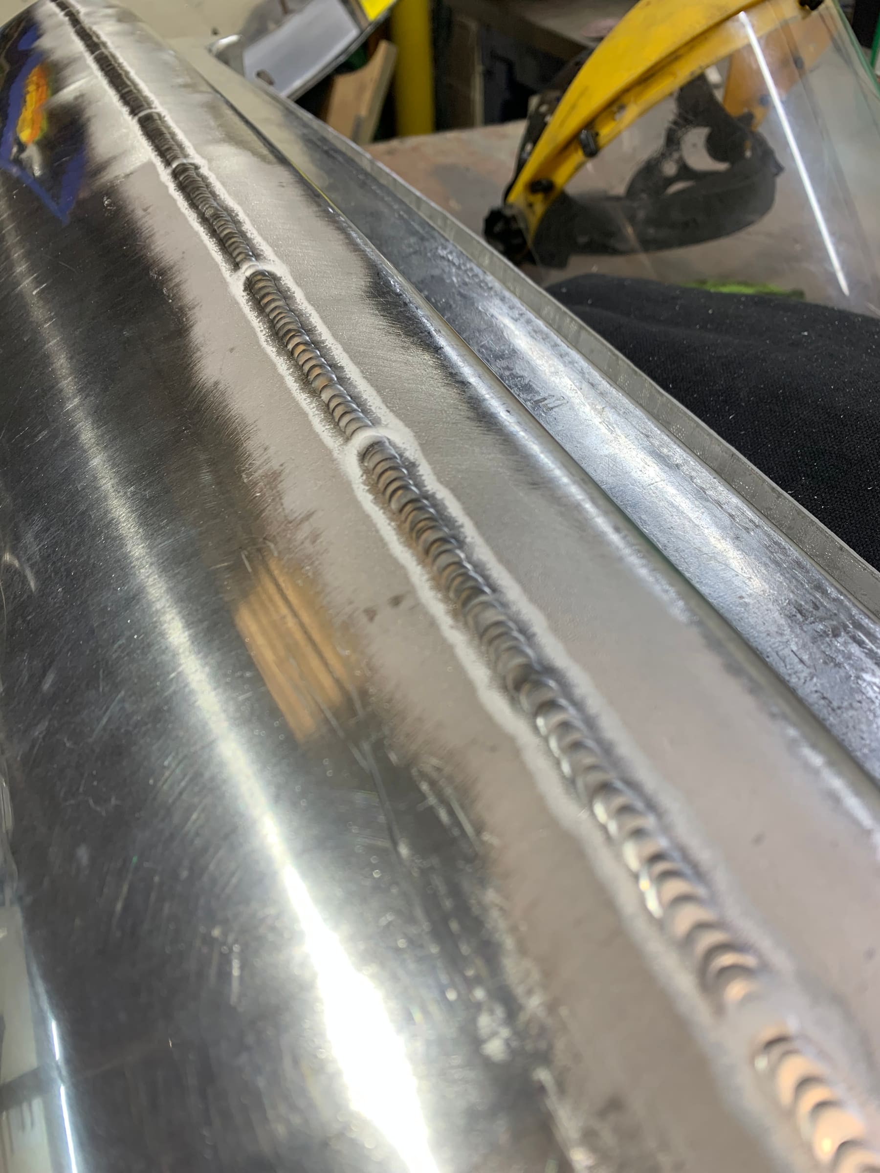 Close-up detail of a hand-finished welded seam on an aluminium panel